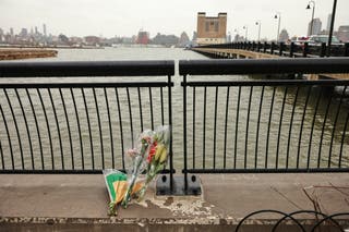 Flowers rest at the end of a pier, Friday, April 11, 2025, near the terrain where a viewing helicopter crashed a day earlier in the Hudson River in Jersey City, NJ (AP Photo/Yuki Iwamura)